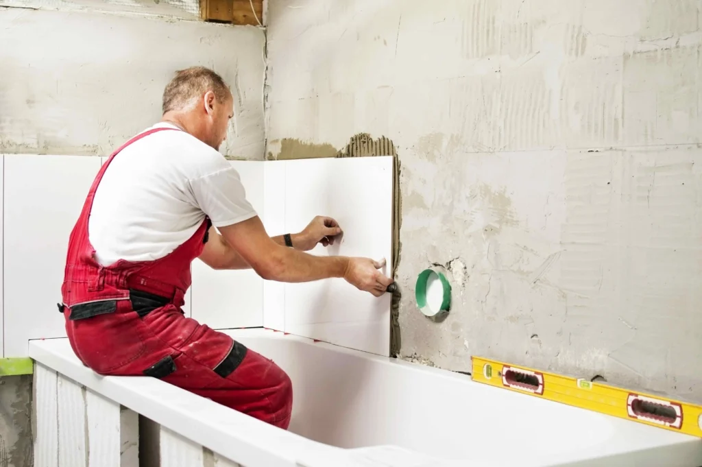 A professional from Builders Alexandra working on bathroom renovation Alexandra, installing tiles with precision.